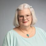 Headshot of smiling women with short straight hair wearing glasses